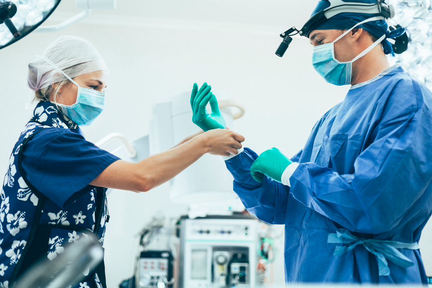 Surgeon and nurse in operating theatre waring PPE